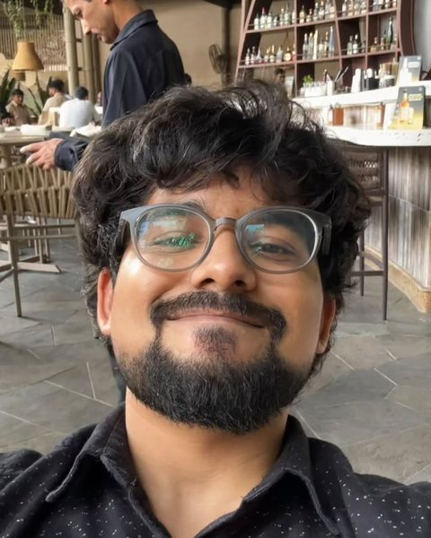 Mihir Okte, at a restaurant table, smiling at the camera